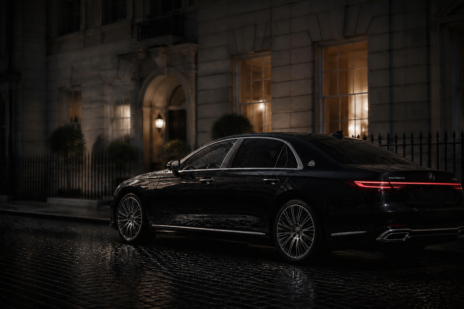Mercedes-Maybach saloon on wet cobbles outside a warmly lit townhouse at night